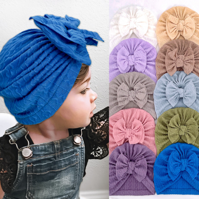 Caciulita tip turban cu model din tesatura si funda aplicata (marime
